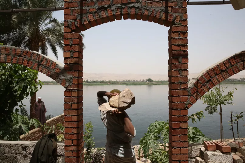 يقوم عمال بناء بدعم الضفاف نهرية على طول نهر النيل لحمايته من التآكل. بعدسة دومينيك شافيز، البنك الدولي.