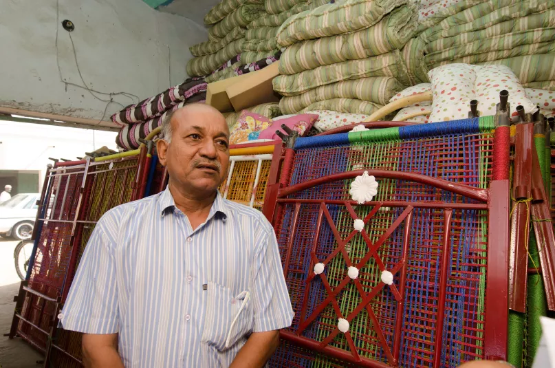 رجل في السودان ساعده قرض التمويل الأصغر على استقرار تجارته للأسِرّة المنسوجة البلاستيكية. بعدسة صلاح الدين نادر، البنك الدولي.
