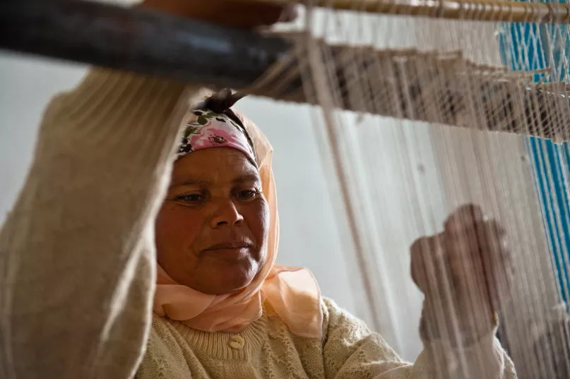 Une femme artisane en Tunisie utilise un métier à tisser.