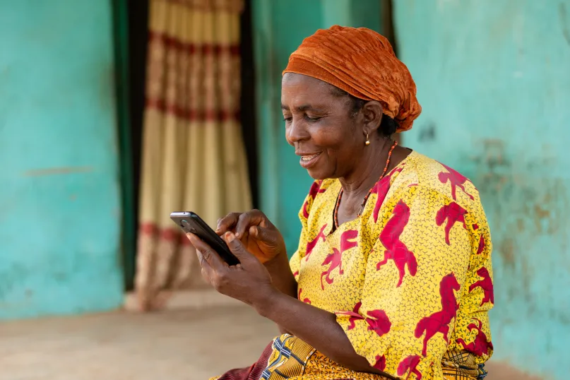 Woman smiling and looking at her mobile phone.