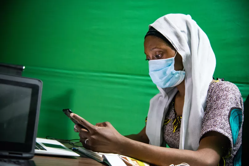 Woman using a mask and a mobile phone in Mali. Nicolas Réméné, 2020 CGAP Photo Contest.