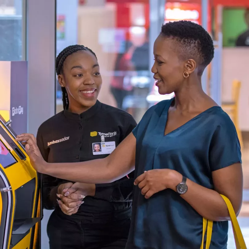 Deux femmes utilisent un kiosque mobile TymeBank dans une banque en Afrique du Sud.