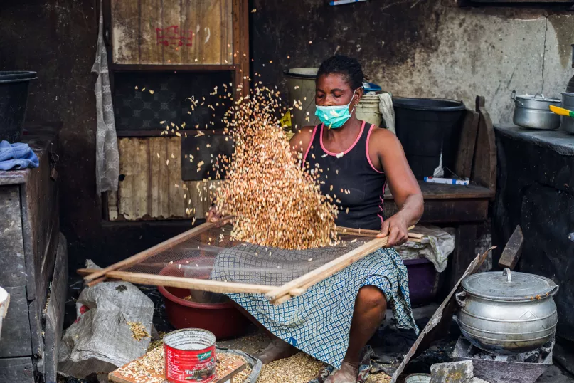 Mujer tamizando frijoles en Lagos, Nigeria.