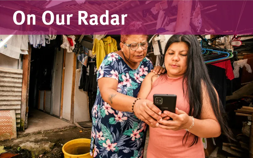 Two women in Colombia look at a phone together.