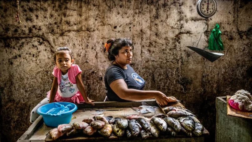 A woman and her daughter selling fish.