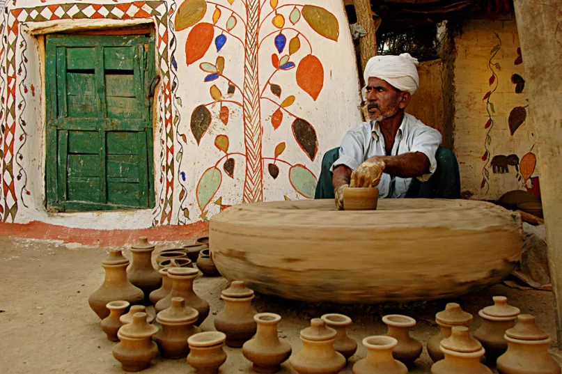 Man in a pottery studio making clay pots