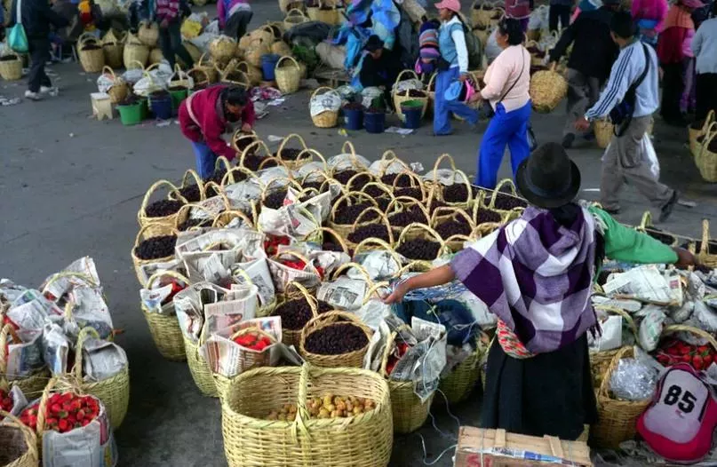 Personas y productos en el mercado de Ambato en Ecuador.