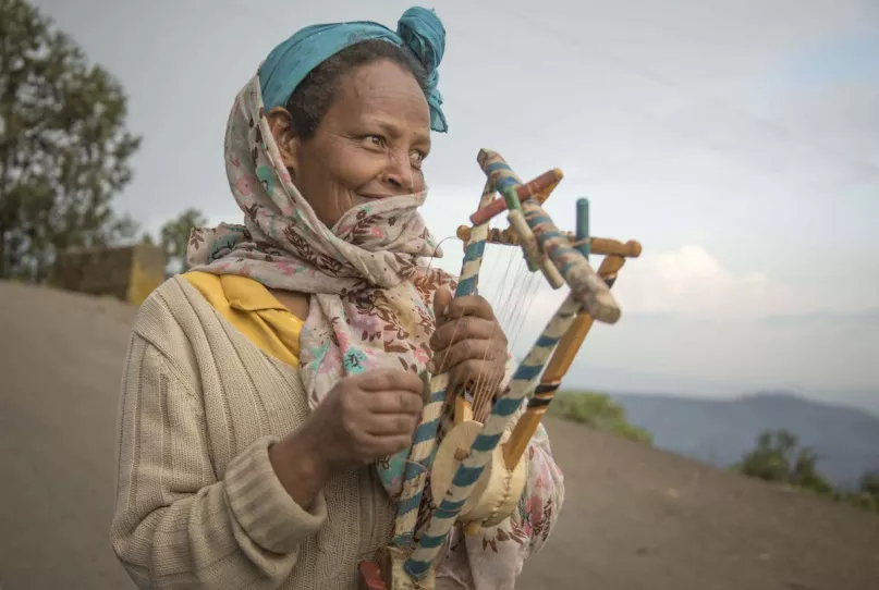 Woman in Ethiopia plays string instrument.
