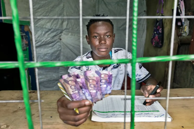 Agent d'argent mobile effectuant un décaissement au Kenya.