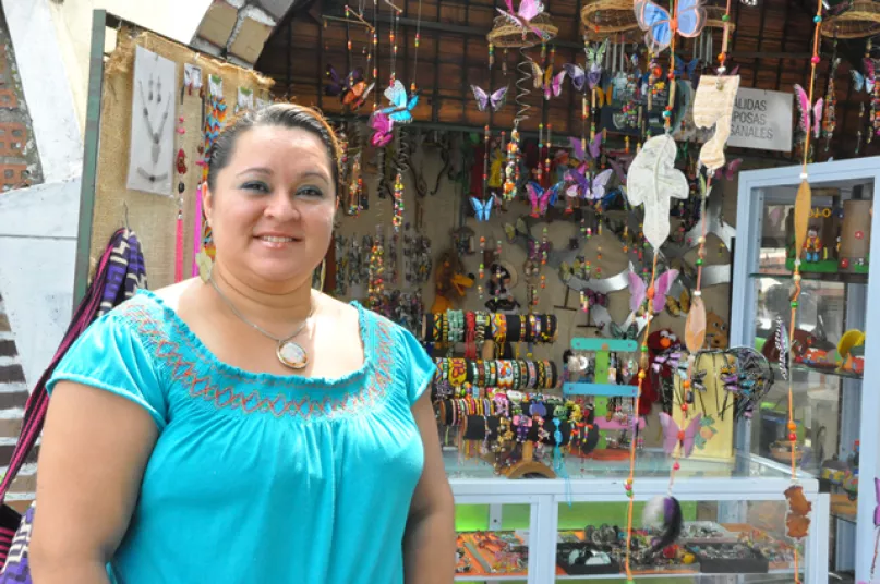 Mujer mostrando sus productos. Foto gentileza Fundación WWB Colombia.