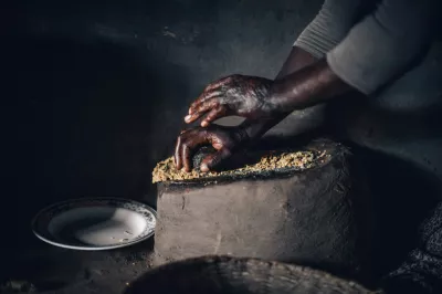 امرأة تصنع زبدة الفول السوداني باليد في أوغندا.