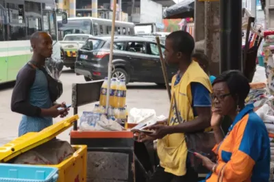 Streetside market with three people at a bottled juice and water seller