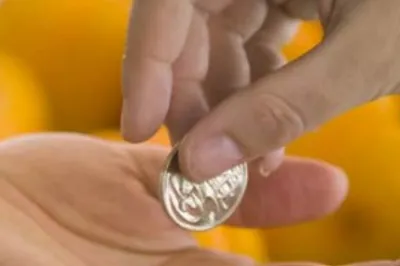 One hand depositing a coin into another hand