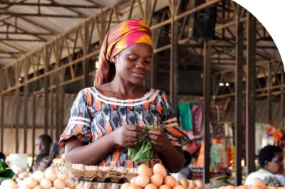 Woman with headscarf selling eggs in a market.