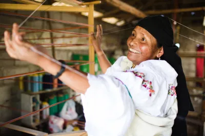 Mujer sonriendo y con telar.