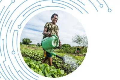 Farmer watering crops with watering can.