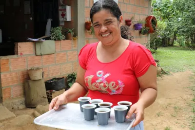 Una mujer colombiana sonriendo y con café.