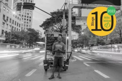 Hombre parado en el centro de una avenida con un celular en sus manos en Brasil, logo Portal FinDev.