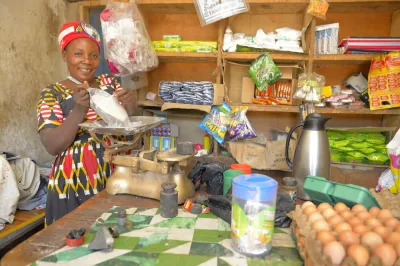 Woman in her shop measuring flour on a scale.