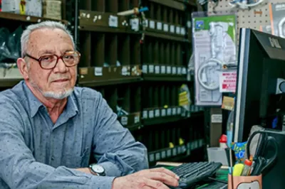 Hombre trabajando en computadora en su negocio en Argentina.