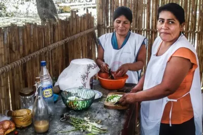 2 mujeres preparando ceviche ante una mesa con los ingredientes en Perú. 