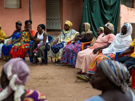 Group of women in Guinea-Bissau sitting at a community meeting.