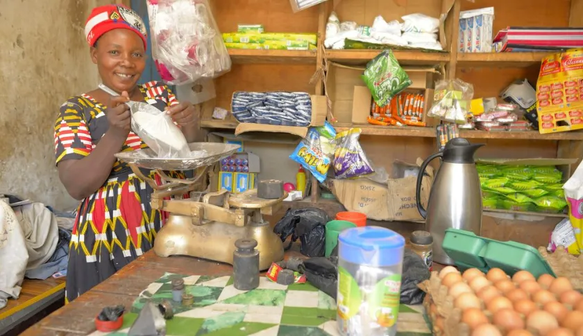 Woman in her shop measuring flour on a scale.