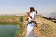 Un homme avec un outils contemple un champ au Moyen-Orient.