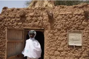Une femme devant sa maison au Burkina Faso.