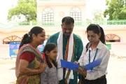 Sales official holding a folder with a family looking at the folder.