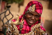 Woman wearing headscarf by water faucet in Niger.