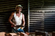 Hombre parado ante una mesa fabricando ladrillos en México.