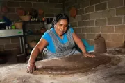 Mujer inclinada sobre una mesa trabajando el barro en México. 