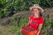 Mujer mostrando granos de café. Foto: Fundación WWB Colombia.