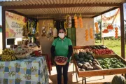 Mujer parada en su puesto de venta de frutas y verduras en Paraguay.