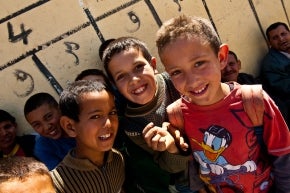 أولاد يبتسمون في ملعب المدرسة في قرية آيت سيدي احساين في المغرب.