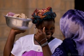 Dos mujeres conversando en Nigeria, una de ellas sostiene un cuenco.