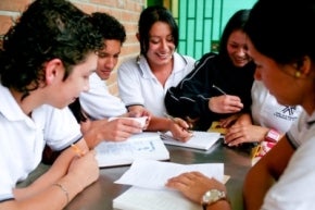 Jóvenes estudiantes con libros alrededor de una mesa en Colombia
